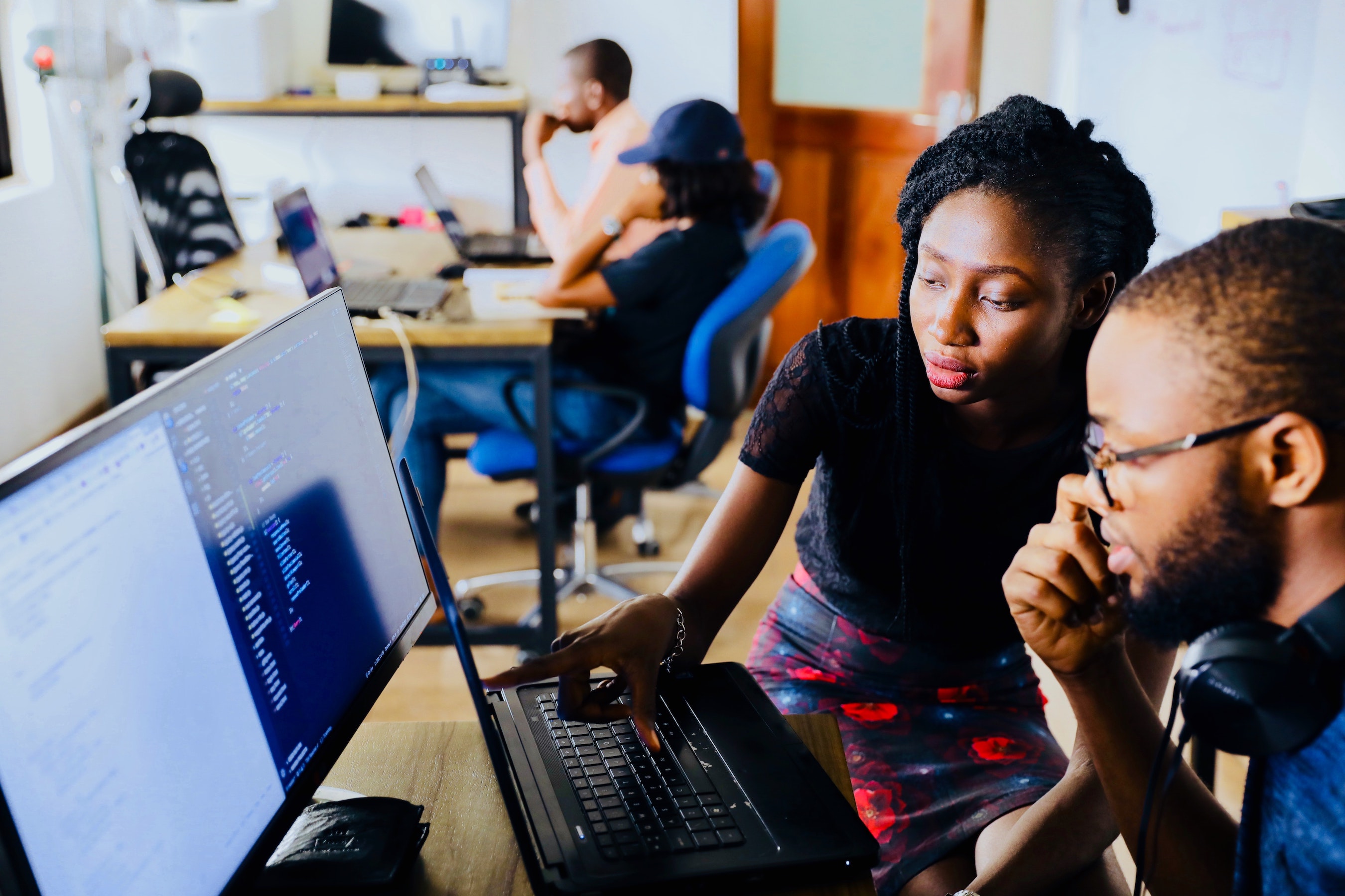 Two people on a laptop working. 