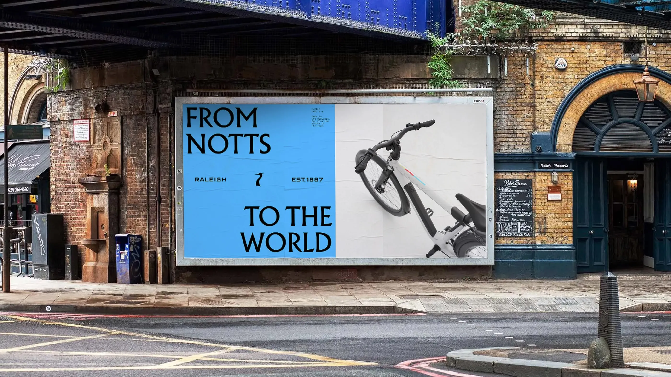 Outdoor billboard for Raleigh bikes that reads "FROM NOTTS TO THE WORLD" next to a white bicycle.